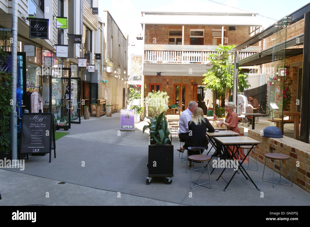 People, tables and shops of Bakery Lane behind Apothecaries Hall, Fortitude Valley, Brisbane, Queensland, Australia. No MR or PR Stock Photo