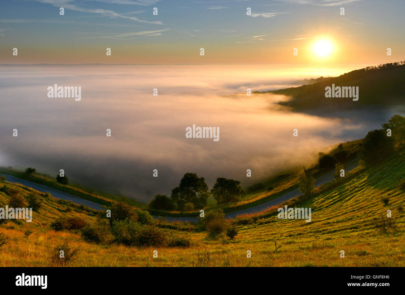 Beautiful sunrise over mist covering the low Weald, from Firle Beacon. Stock Photo