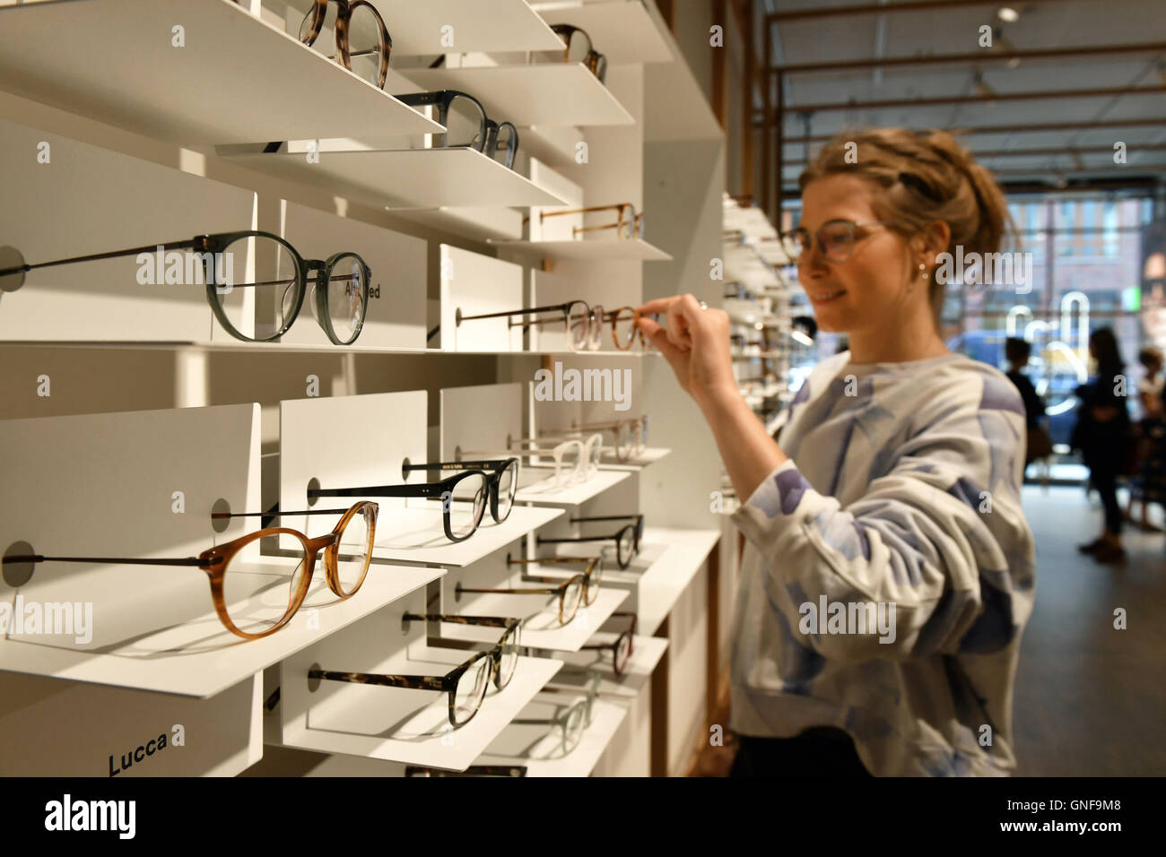 Berlin, Germany. 23rd Aug, 2016. Cora Wollenstein, employee at 'Ace and Tate',  arranges glasses in the flagship store of the Dutch glasses brand 'Ace and  Tate' in Neue Schonhauser Strasse in Berlin,