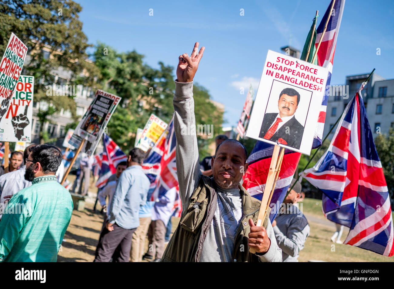 London, UK, 30th August 2016. Protester makes a V-sign (peace sign) while holding a placard reading: 'Stop Force Disappearance in Bangladesh'. Bangladeshi activists demonstrate in London as the Supreme Court in Bangladesh upholds Jamaat-e-Islami, the country's largest Islamic party's senior leader's, Mir Quasem Ali’s death sentence. The leader is being accused for committing war crimes during the Bangladesh's 1971 Liberation War against Pakistan. Credit:  ZEN - Zaneta Razaite / Alamy Live News Stock Photo