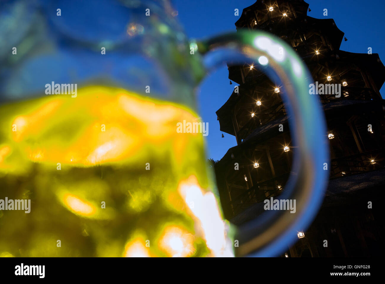 Munich, Germany. 30th Aug, 2016. A half-empty beer jug stands in front of an illuminated Chinese tower after sundown at the English Garden in Munich, Germany, 30 August 2016. Photo: Peter Kneffel/dpa/Alamy Live News Stock Photo