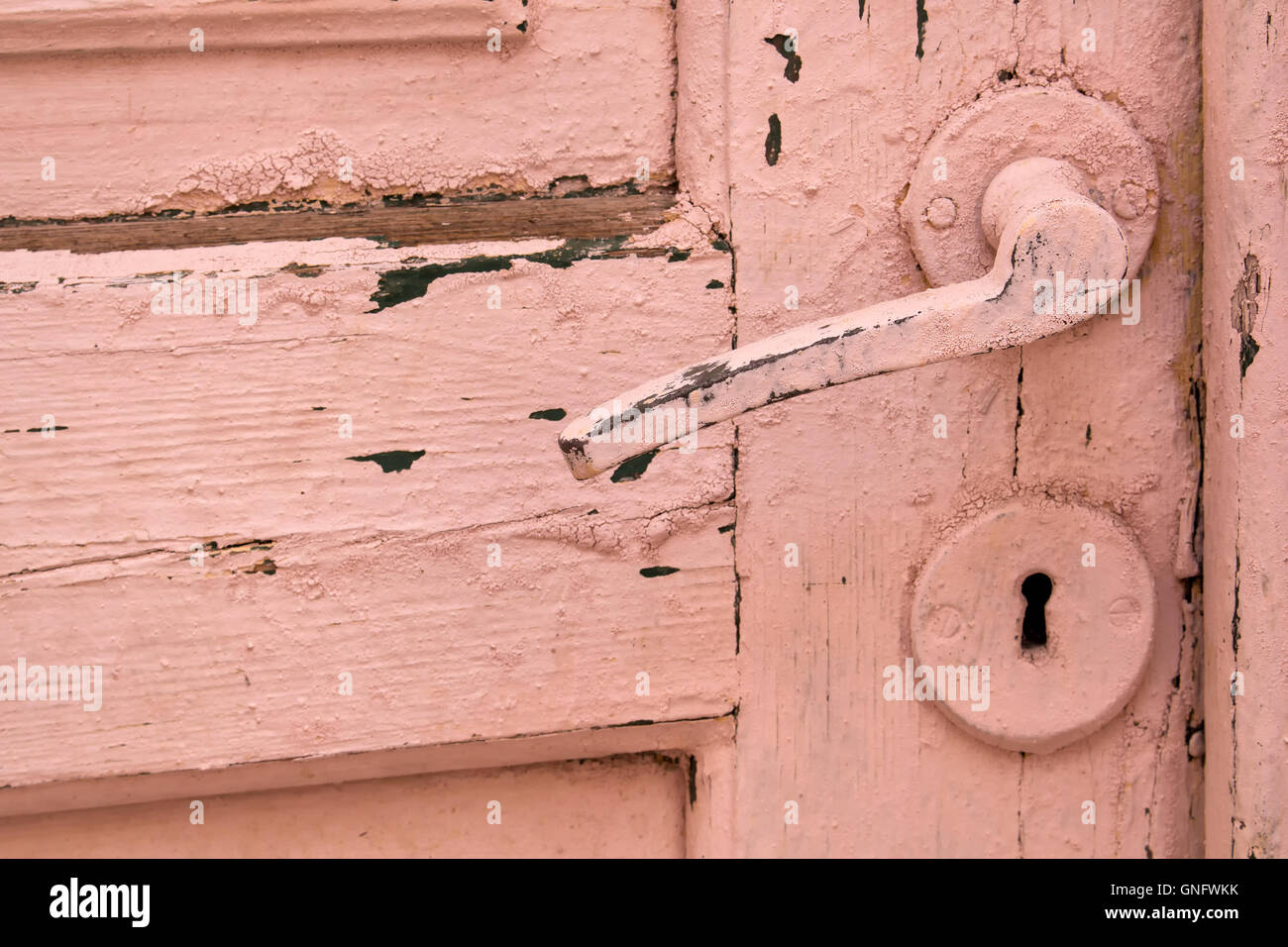 Old wooden door, painted with rose color, including the lock and handle. Stock Photo