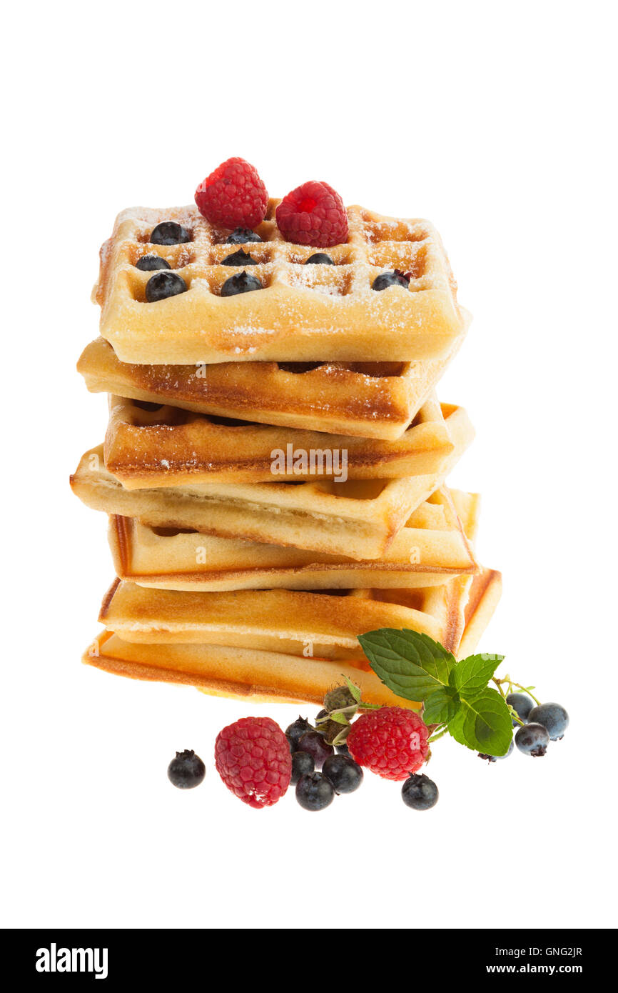 Stack of Belgian waffles with blueberries, raspberries and confectioner's sugar isolated on white background Stock Photo