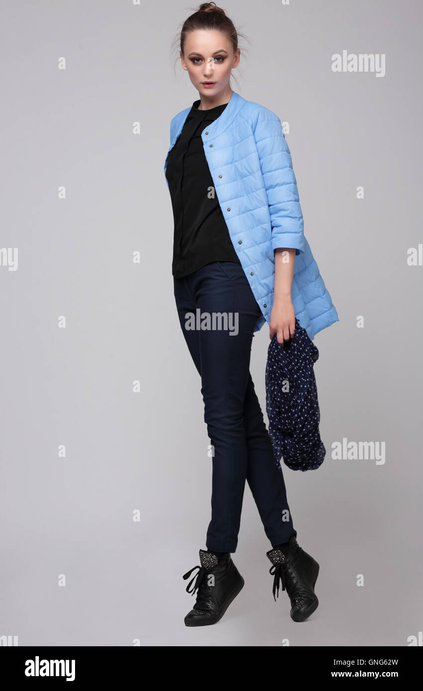 Female model posing in a studio full length. Fashion,  jacket, blue. Youth. Stock Photo