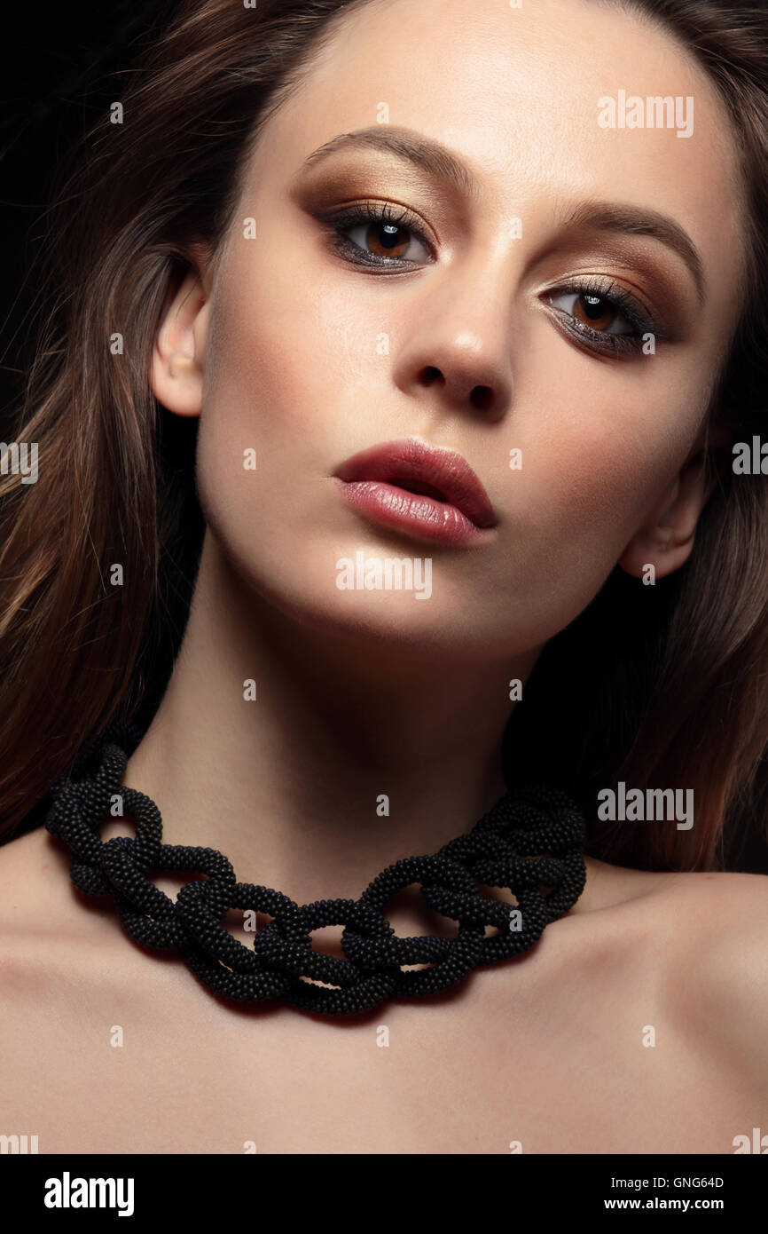 Close-up portrait of young woman with bronze smokey eyes. Modern fashion make-up. Studio shot Stock Photo
