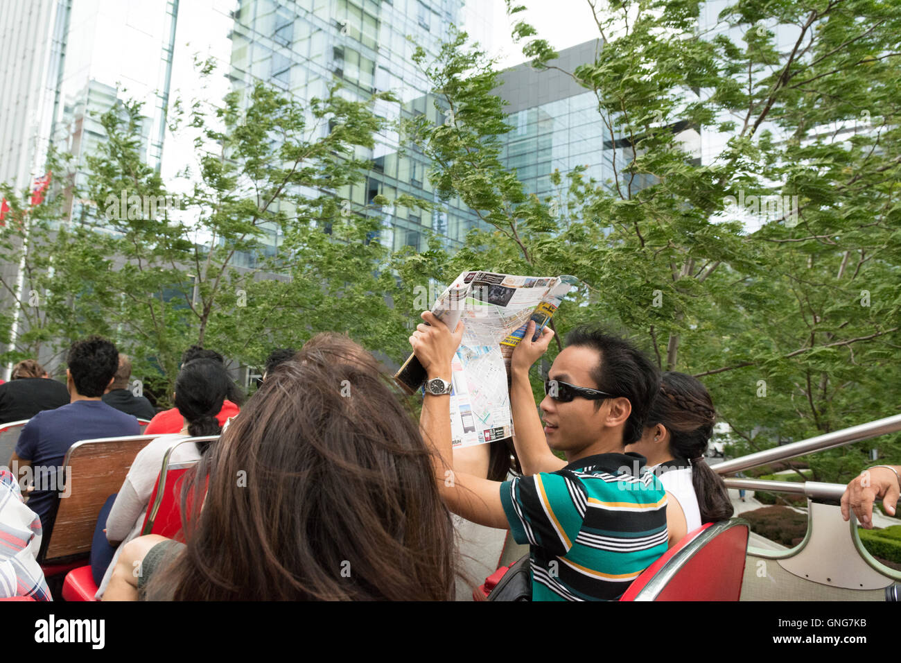 tourists on open topped sightseeing bus in wind and rain shower - Toronto, Canada Stock Photo