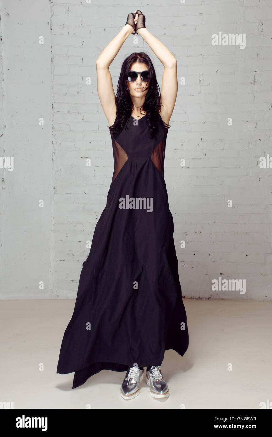 Model black dress wind blowing hair, hands tied Stock Photo