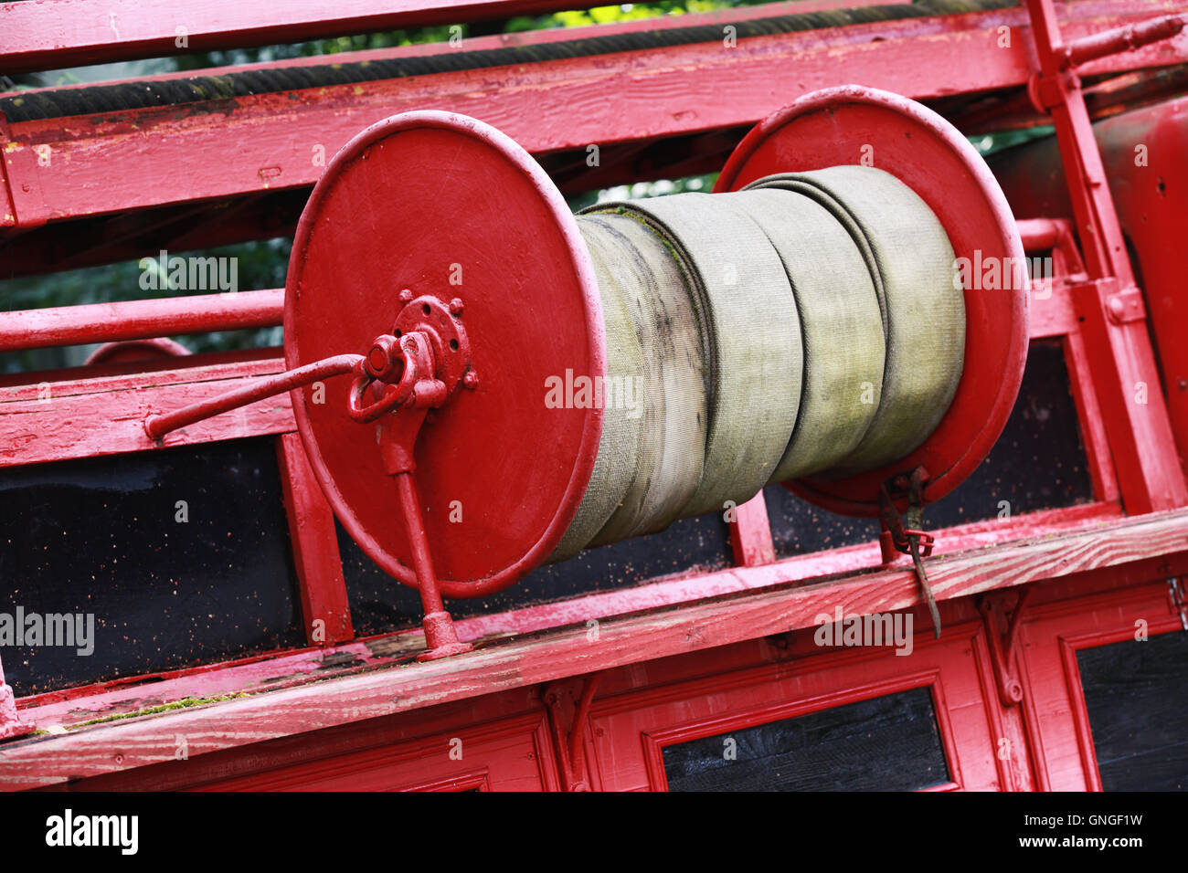 Old red fire hose reel, closeup photo with selective focus Stock Photo