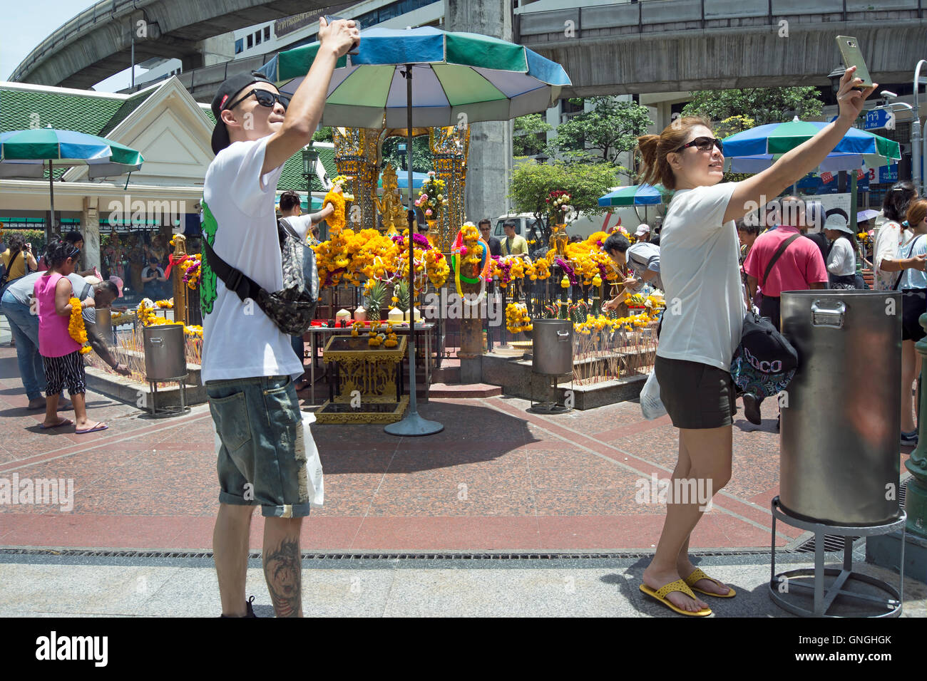 asian tourists take selfies at the erawan shrine, bangkok, thailand Stock Photo