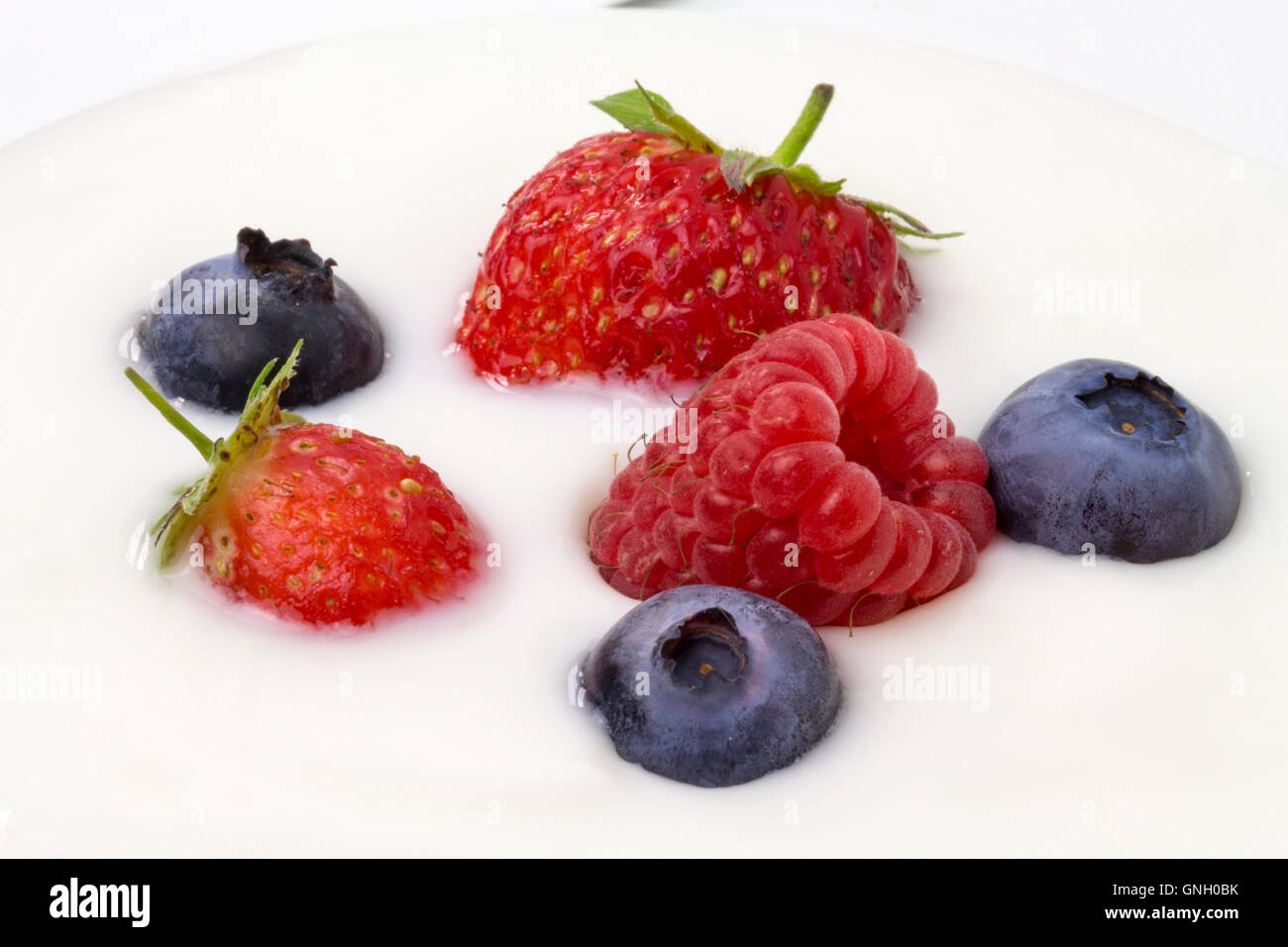 close-up of white yogurt with blueberries, strawberries and raspberries Stock Photo