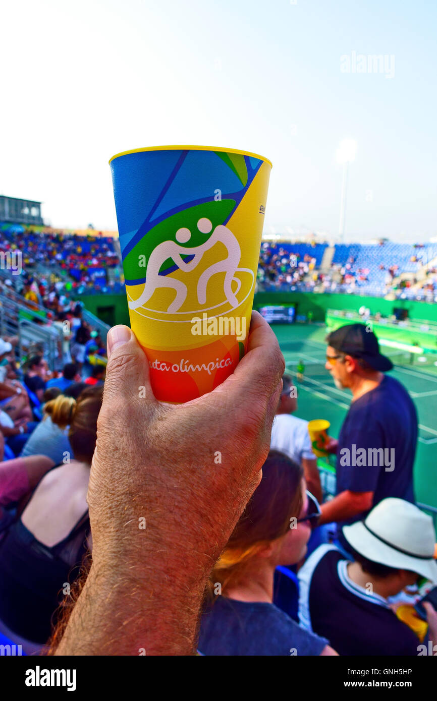 Hand holding an Olympic tumbler depicting wresting . These were given with Skol beer inside the Rio Olympic venues Stock Photo