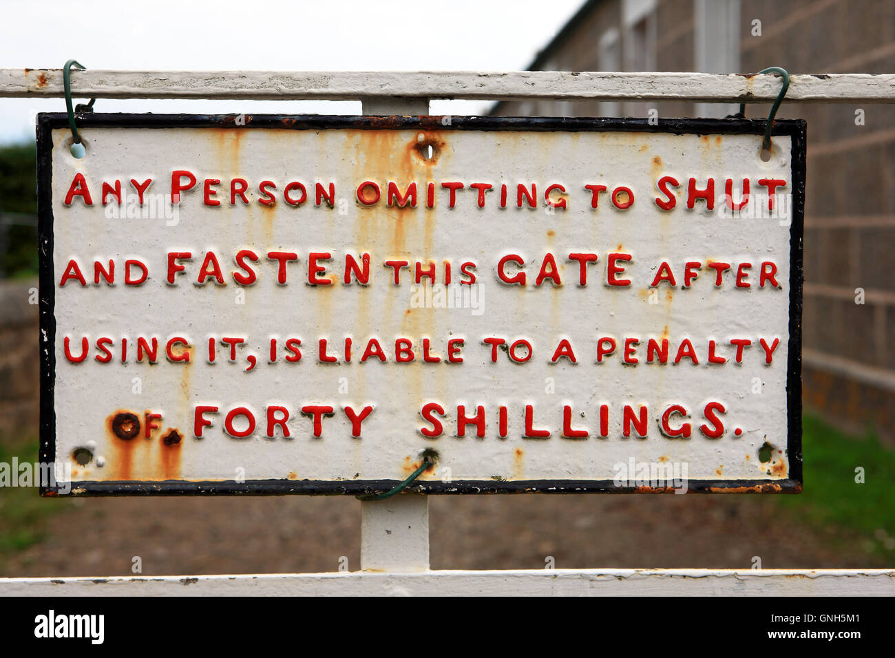 Old gate sign 'Any person omitting to shut and fasten this gate after using it, is liable to a penalty of Forty Shillings' Stock Photo