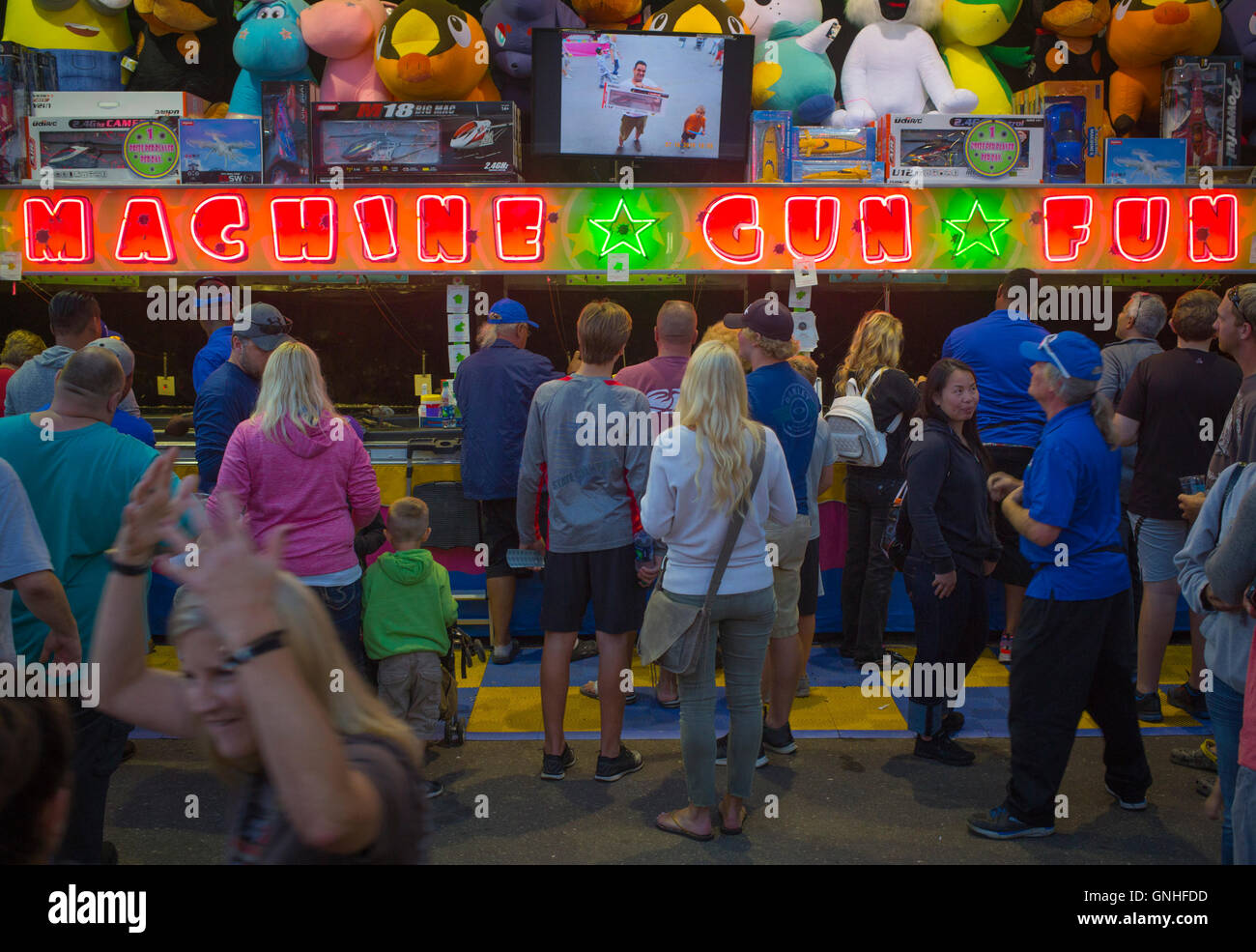 Visitors gather around a shooting gallery called 'Machine Gun Fun' at the Minnesota State Fair, August  27, 2016 Stock Photo