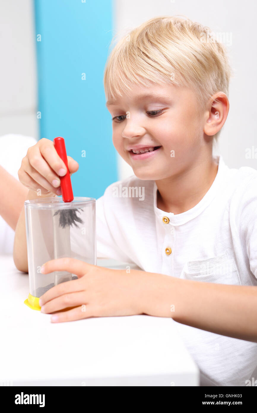 Magnetism, attraction. Child sees the phenomenon of magnetic field on the lessons of physics. Stock Photo