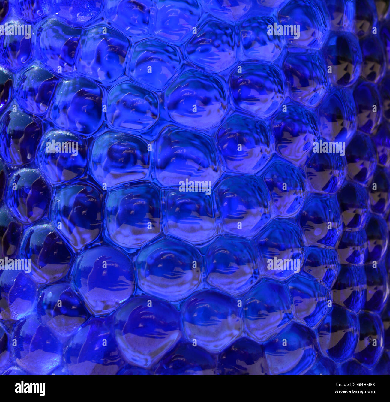Dotted dark blue glass for backgrounds. Bubbly blue glass like liquid. Stock Photo