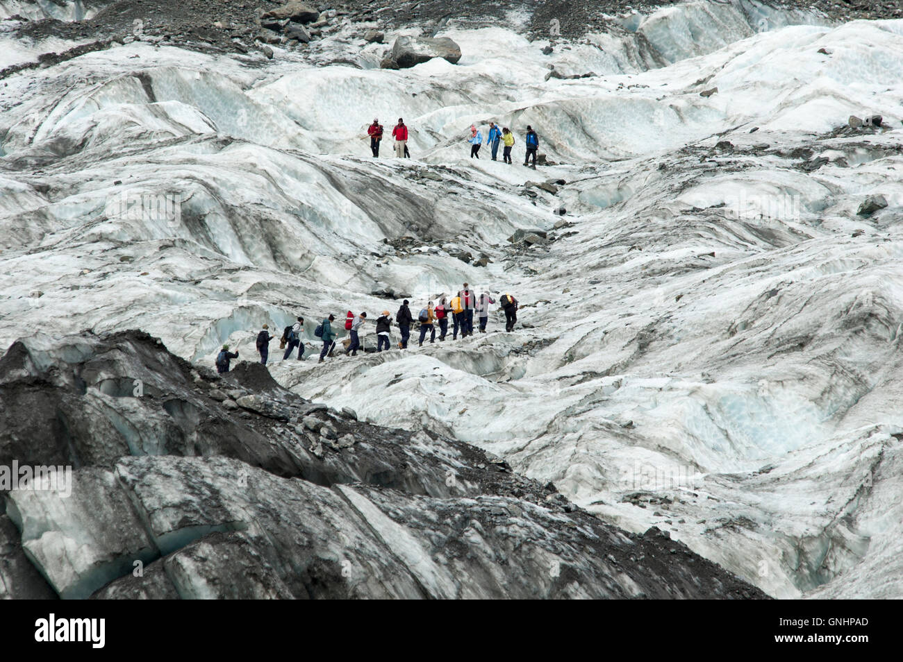 On top of Fox glacier in the Southern Alps of New Zealand tourist are guided in spectacular tours. Stock Photo
