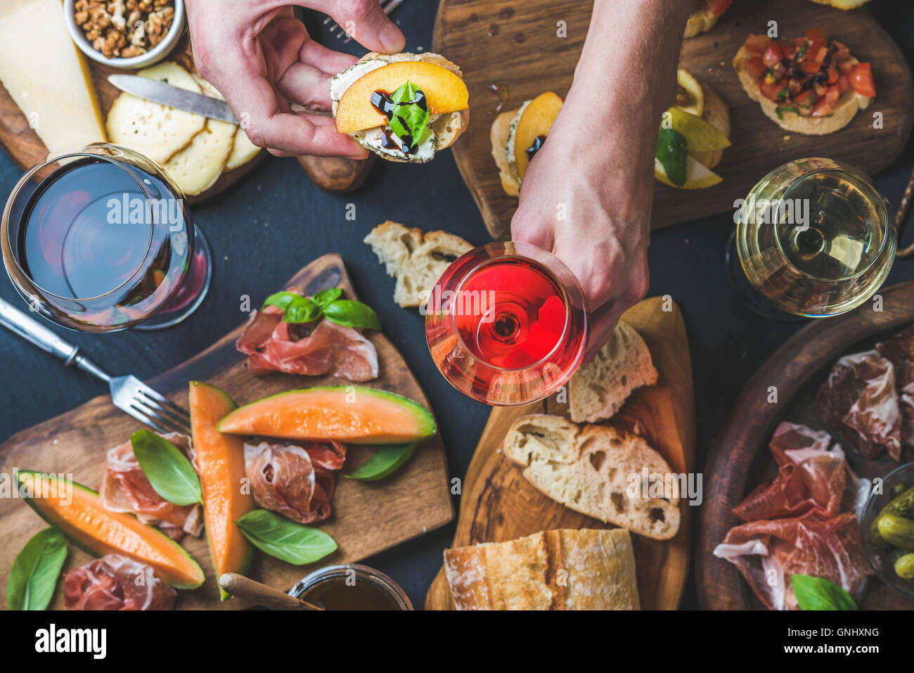 Italian wine antipasti snack variety and man's hands holding glass of