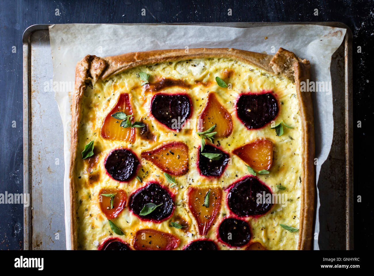 Beetroot ricotta cheese tart with beet greens pesto. Stock Photo