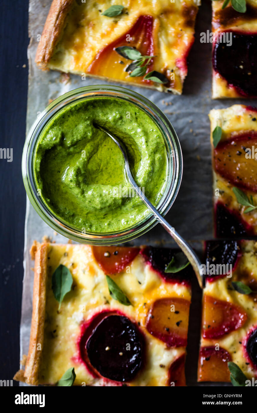 Beetroot ricotta cheese tart with beet greens pesto. Stock Photo