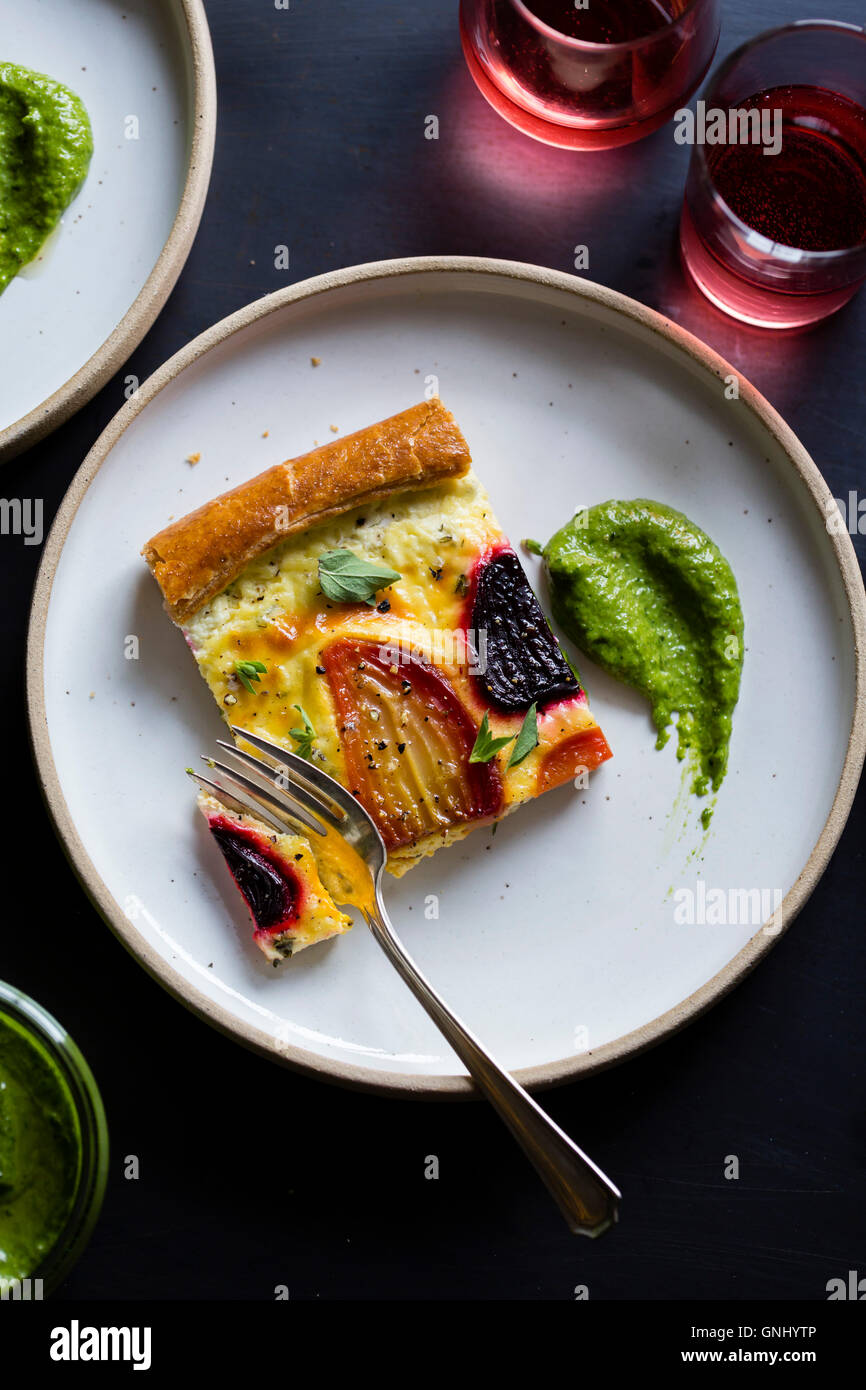 Beetroot ricotta cheese tart with beet greens pesto. Stock Photo