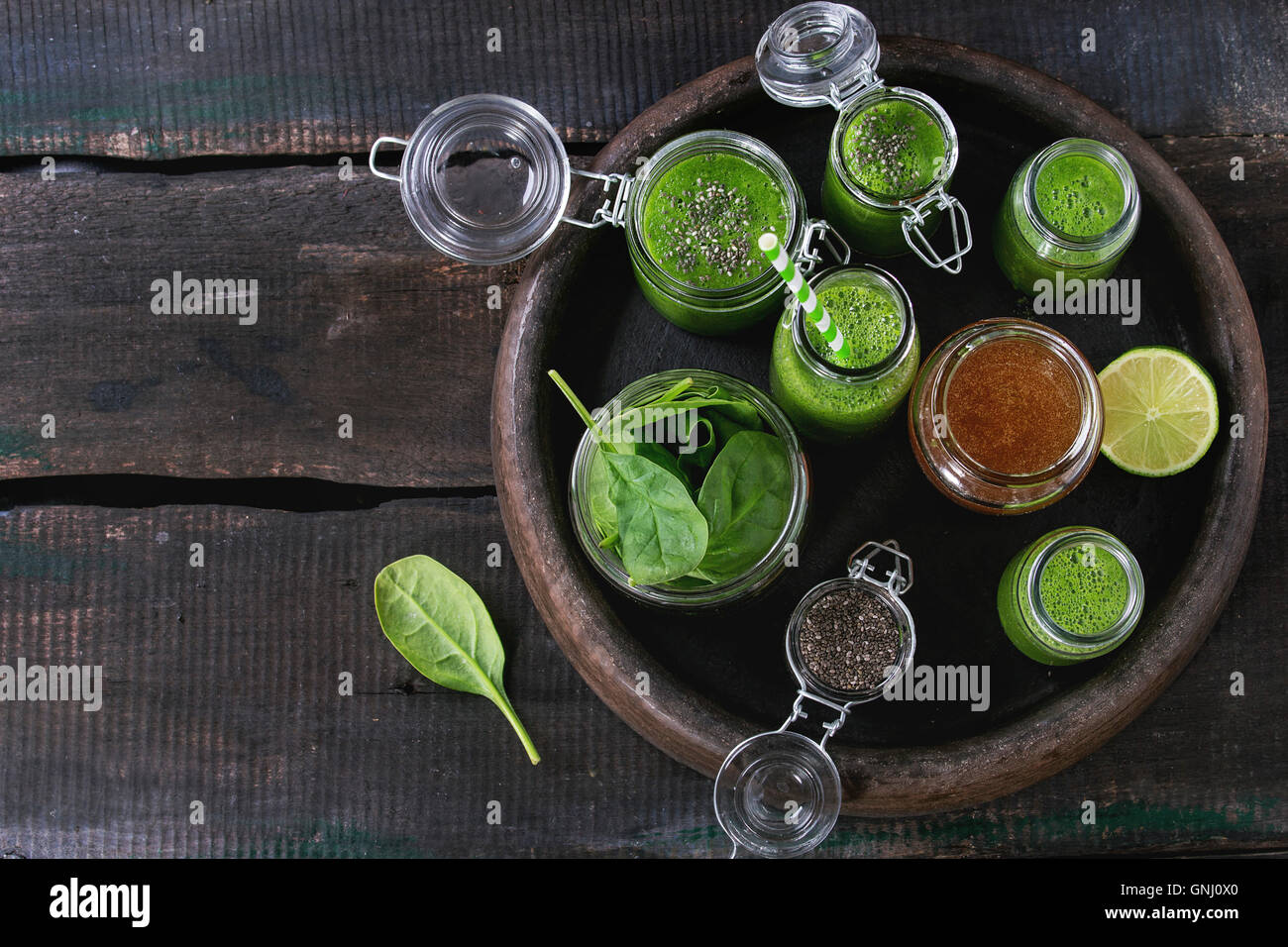 Opened glass jars and bottle of green spinach smoothie, served with