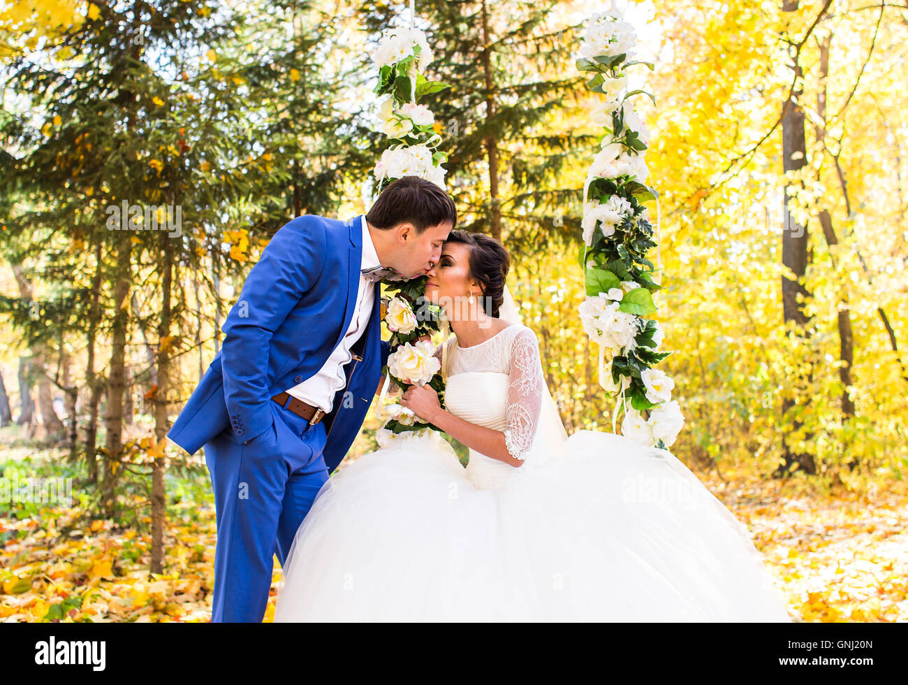 The bride and groom on a swing in autumn park Stock Photo - Alamy