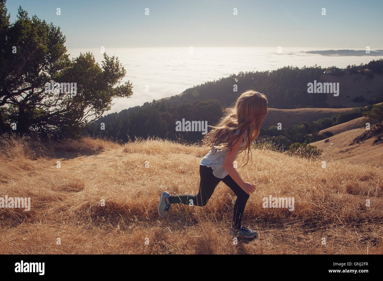 Girl running down mountain, California, United States Stock Photo