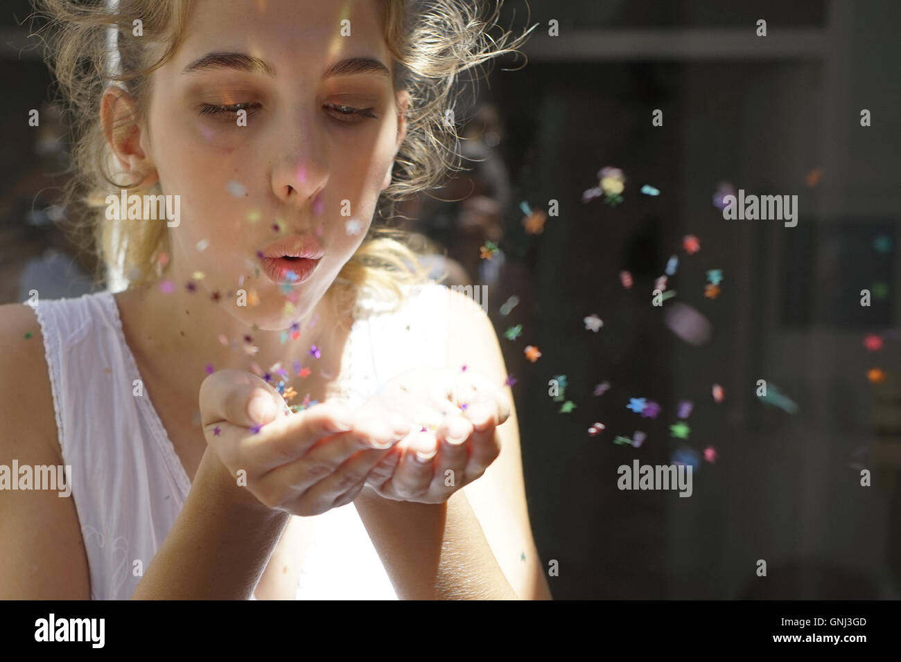 Girl blowing confetti stars Stock Photo Alamy