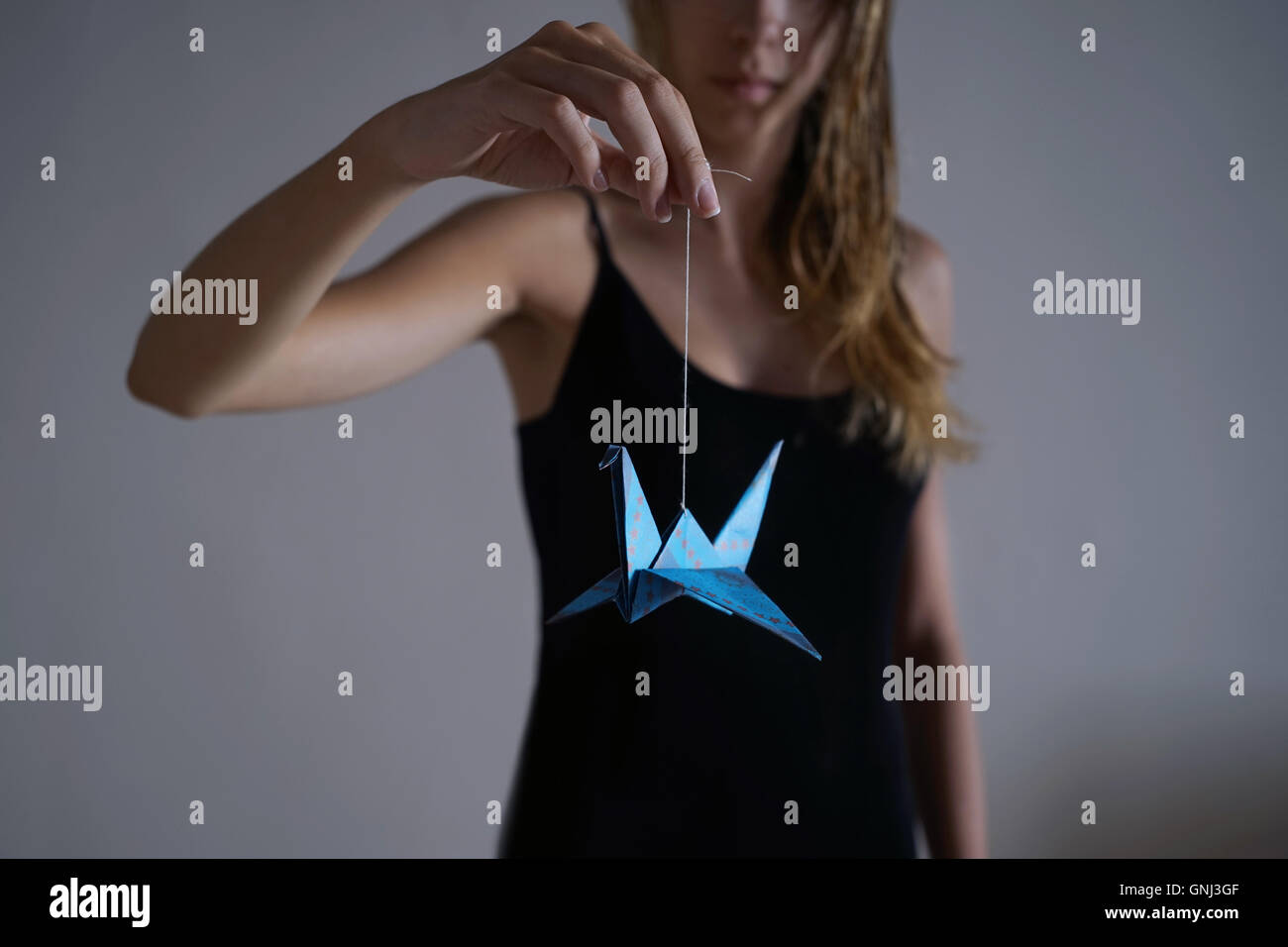 Girl holding an origami paper bird Stock Photo