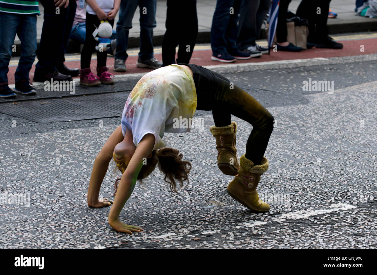 Young girl in Ugg boots bending over backwards taking part in the  Cavalcade, part of the Edinburgh Jazz Festival Stock Photo - Alamy