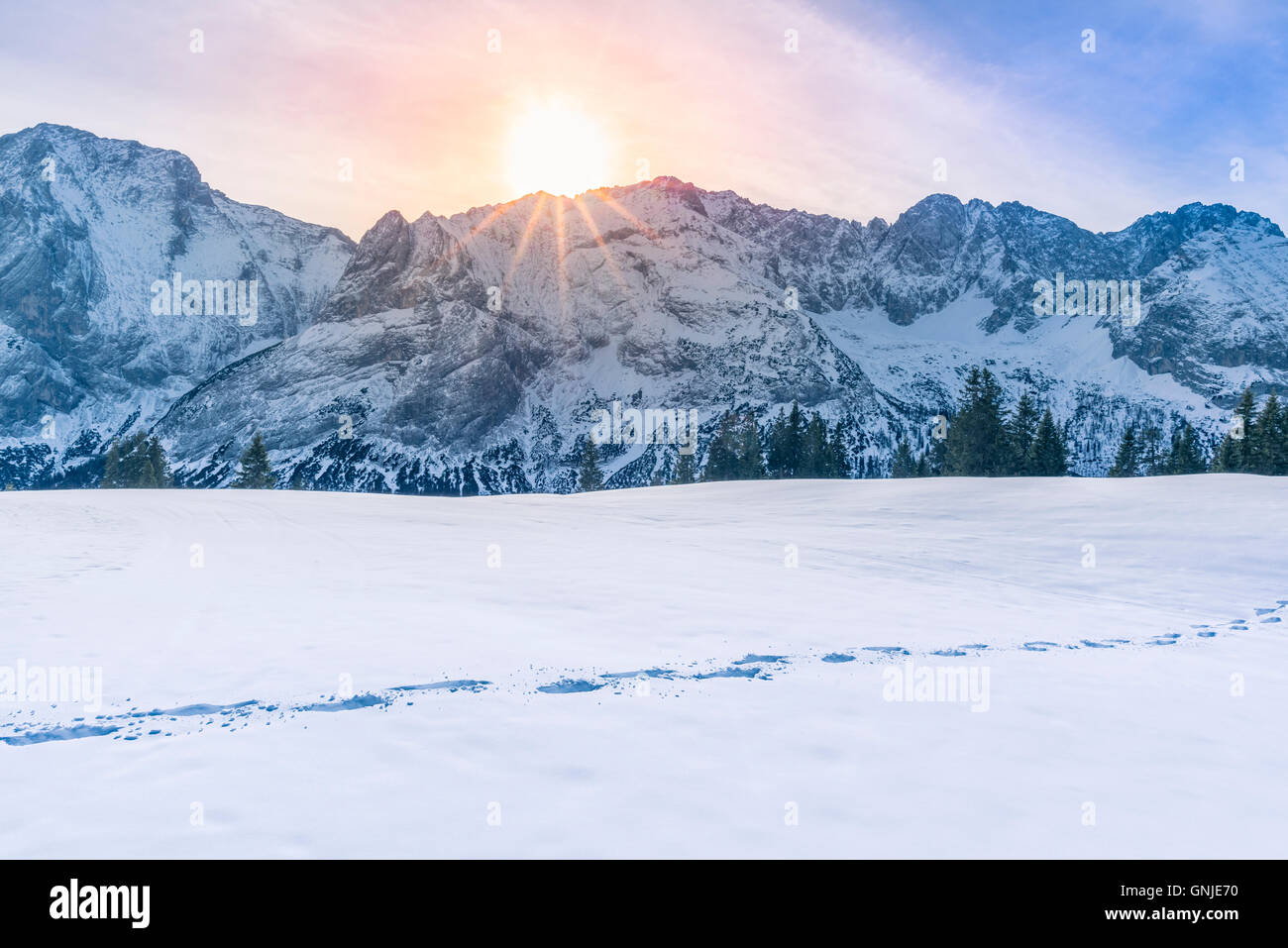 Sun shining over mountain peaks and snow Stock Photo - Alamy