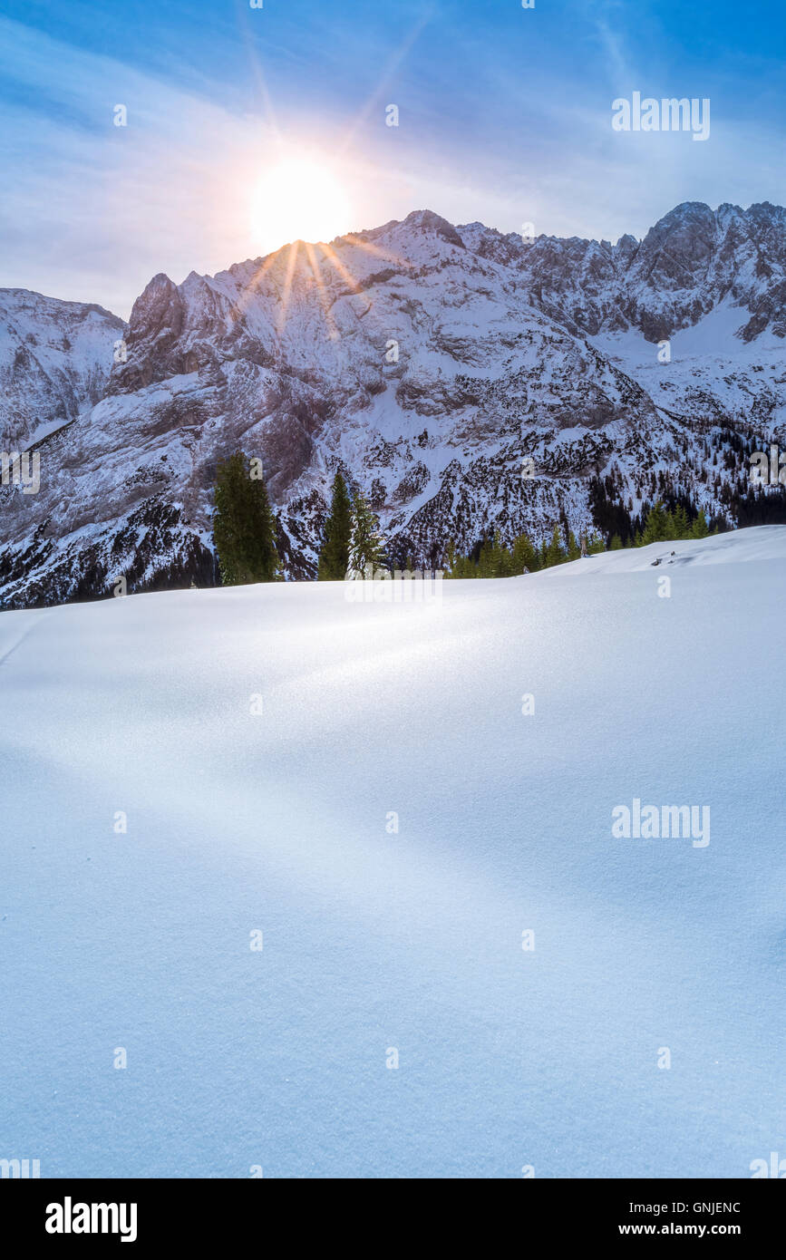 Winter sun over snowy mountain peaks Stock Photo - Alamy