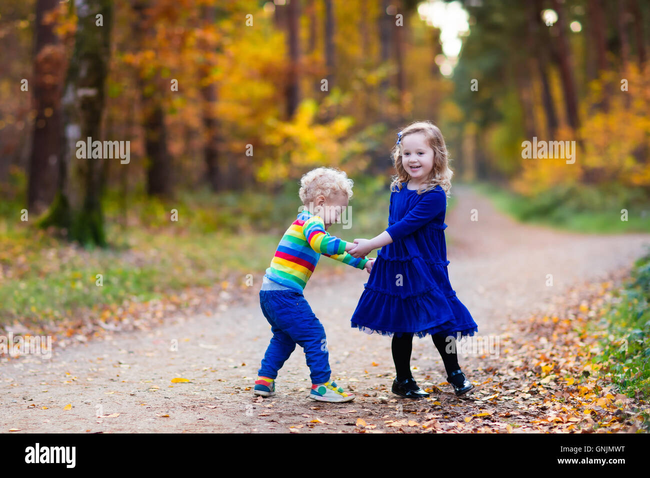 Happy children playing in beautiful autumn park on warm sunny fall day ...
