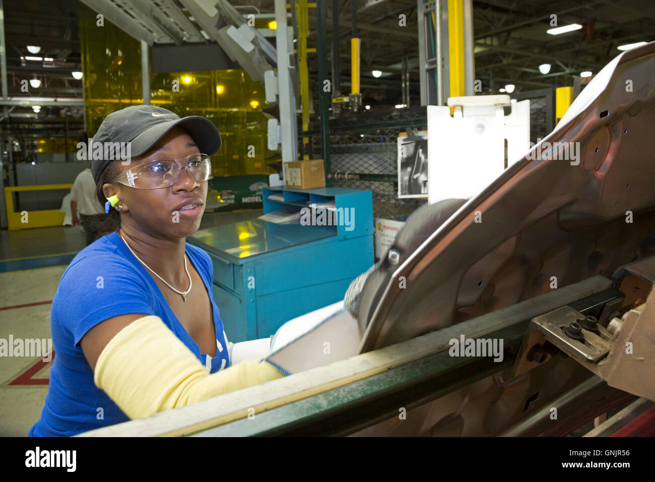 Sterling Heights, Michigan - A worker cleans an automobile hood after it has been stamped and welded. Stock Photo