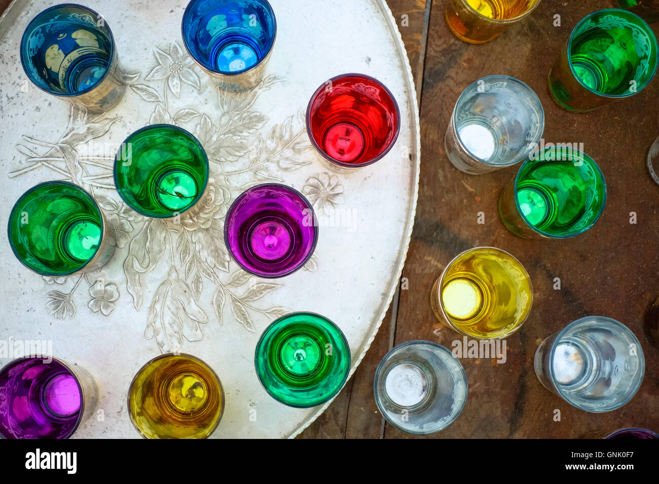 Group of colourful moroccan tea glasses on engraved serving tray. Stock Photo