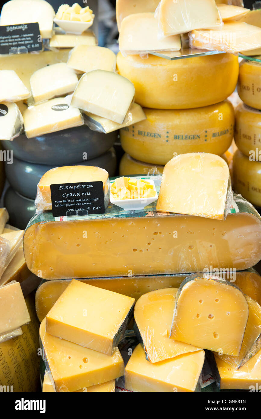 Cheese wheels and wedge on display shelves at traditional cheese shop