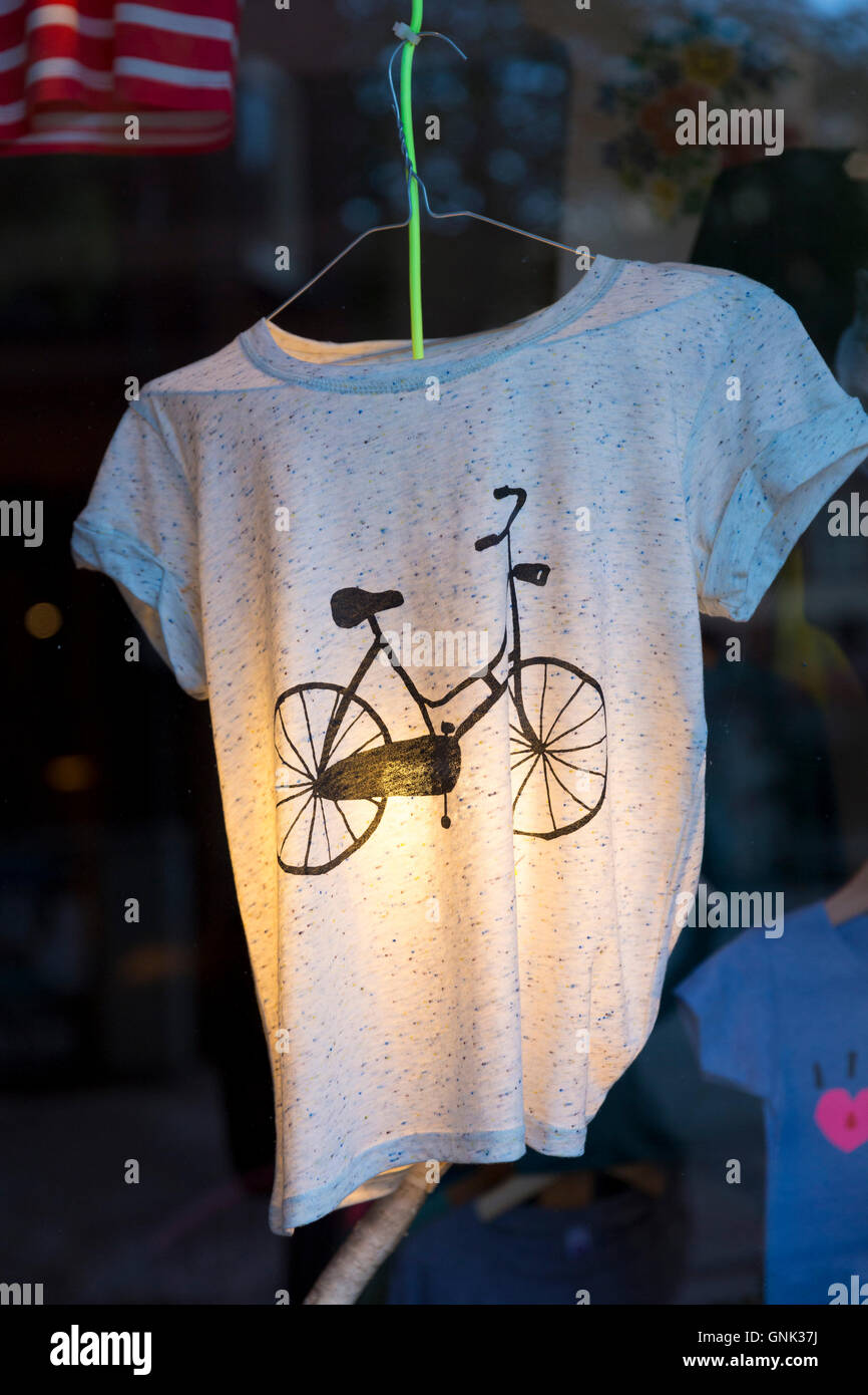 Old bicycle design motif on tee shirt - T shirt - in clothes shop window in the Nine Streets shopping district of Amsterdam, Hol Stock Photo