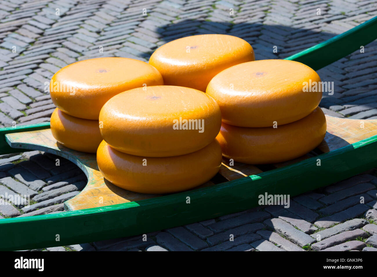 Wheels / rounds of Gouda cheese on sled / stretcher at Waagplein Square, Alkmaar cheese market, The Netherlands Stock Photo