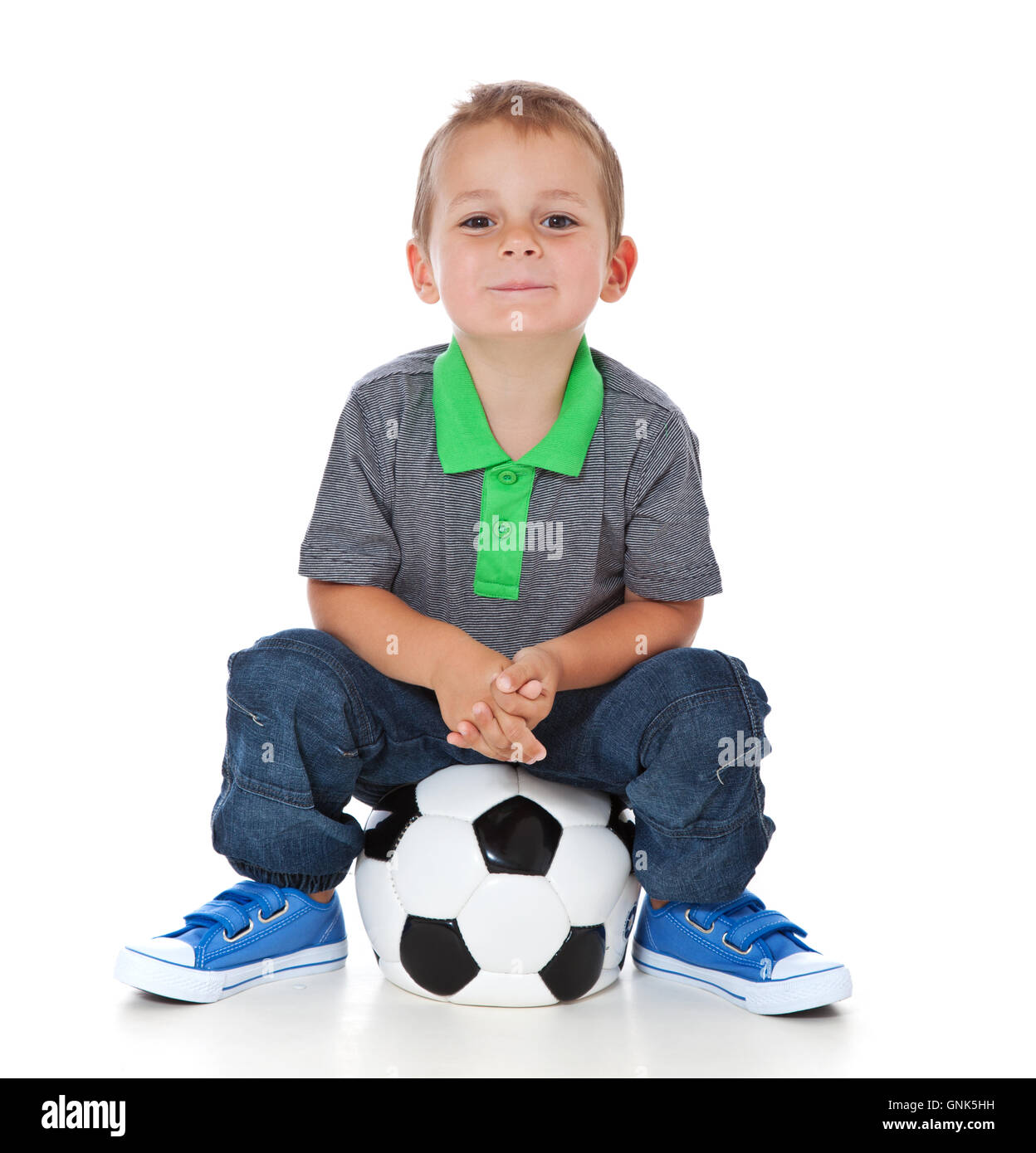 Boy sitting at soccer ball Stock Photo