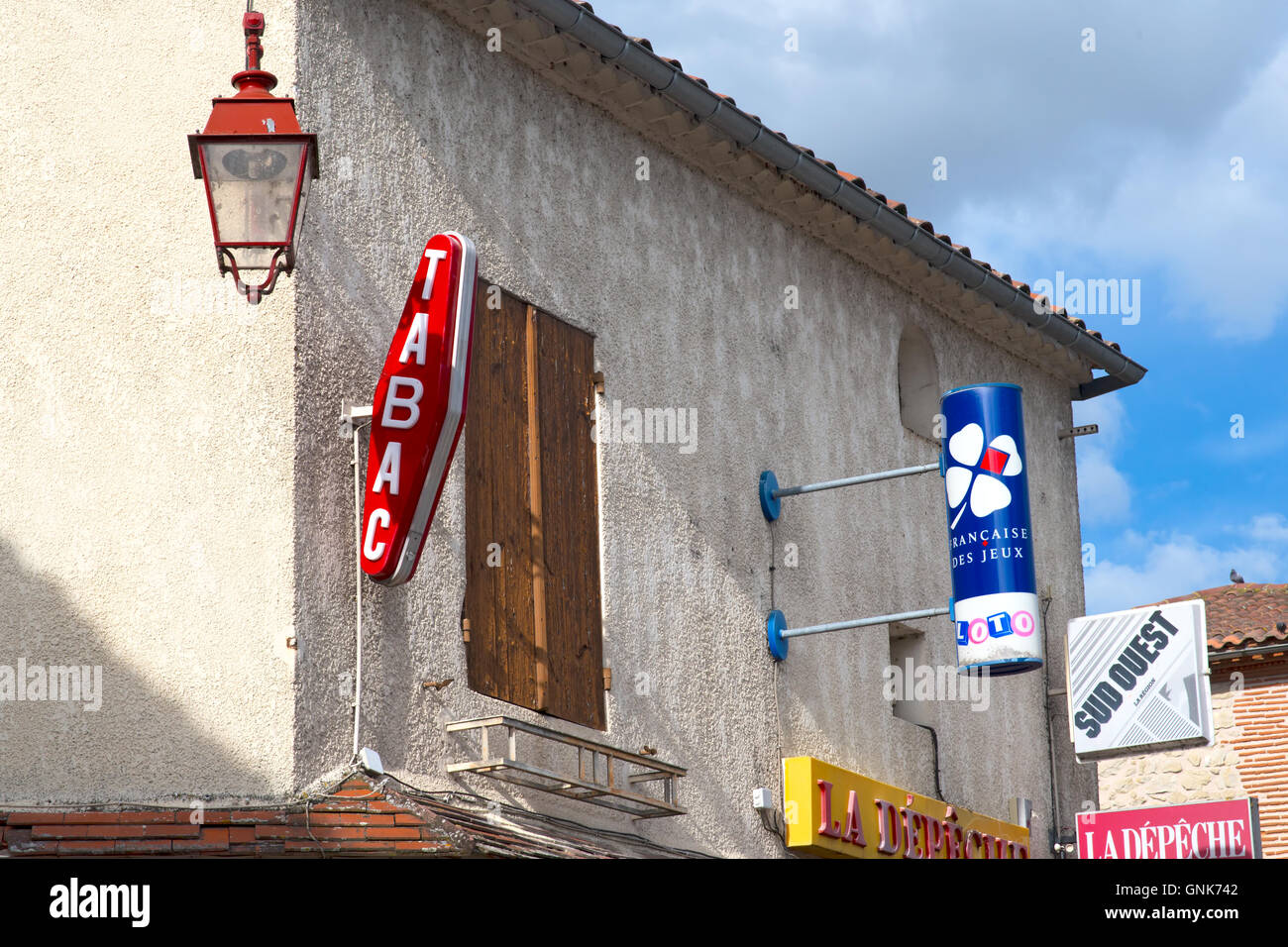 Tabac French advertising hoardings outside of shop with old street light typical Stock Photo
