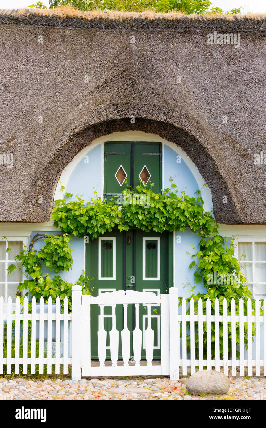 Traditional and quaint thatched cottage house and white picket fence on Fano Island, South Jutland, Denmark Stock Photo