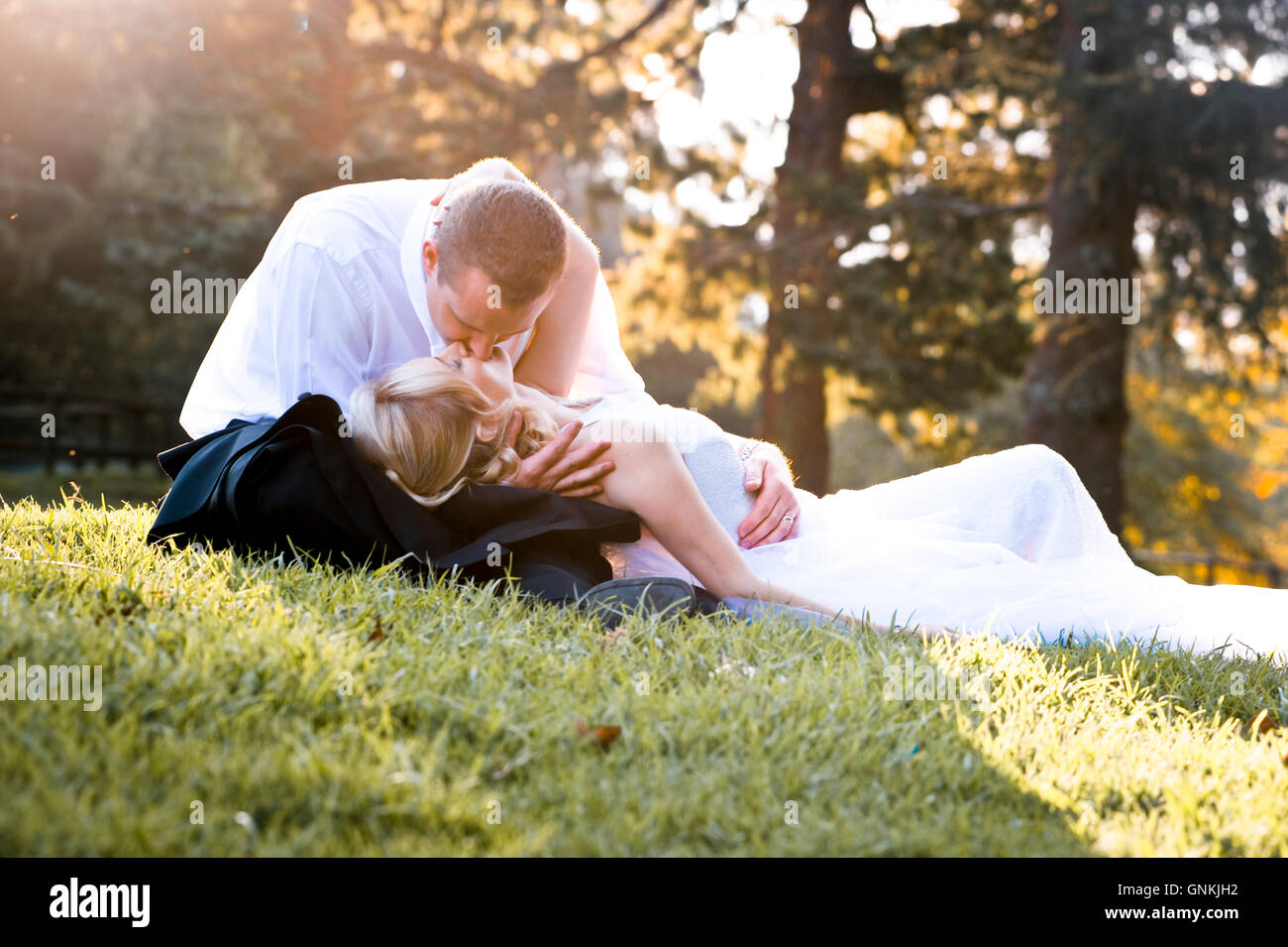 Couple kissing in a park Stock Photo - Alamy