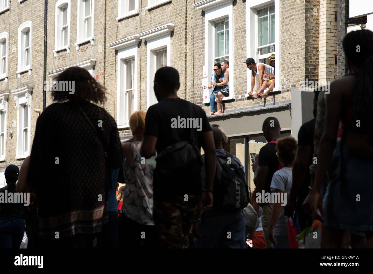 People looking out of windows watching The Notting Hill Carnival in London Stock Photo