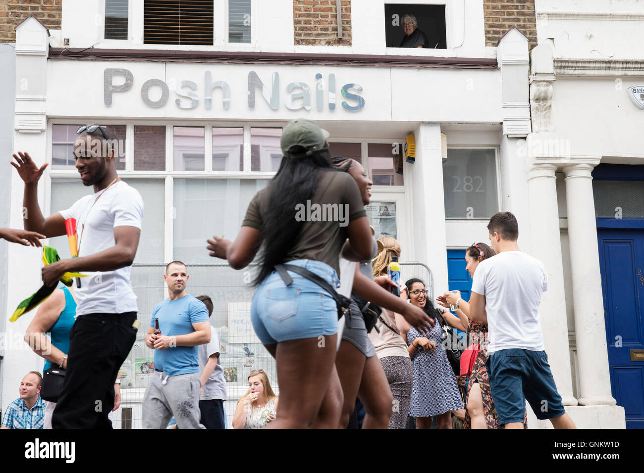 Resident watching revellers at Notting Hill Carnival in London Stock Photo