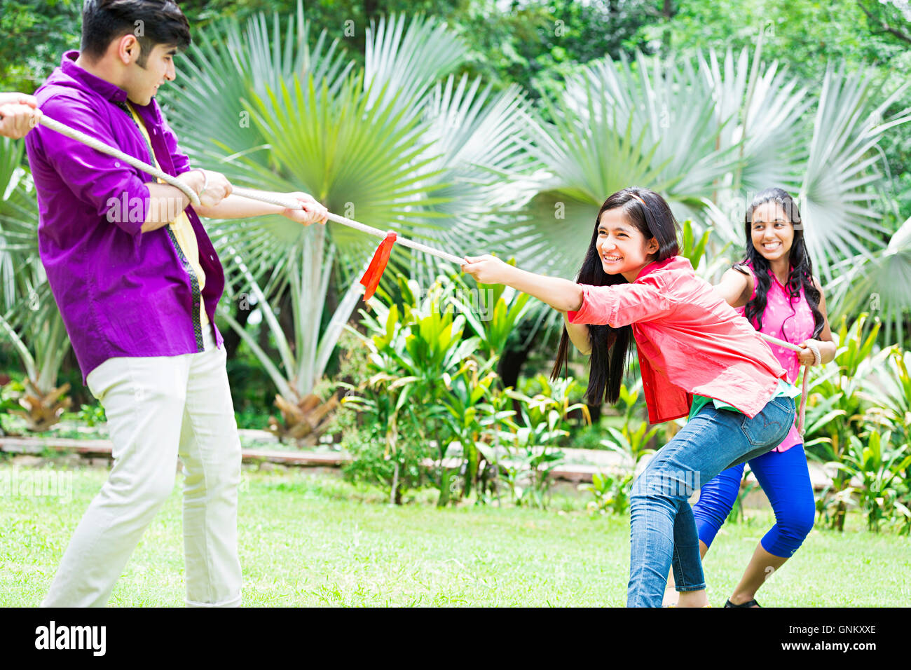 3 Young Girls and Boy Friends park Fun Playing Tug of war Stock Photo