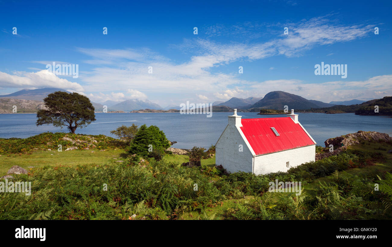 Small cottage with red roof beside Loch Shieldaig in Torridon, on North Coast 500 tourist route, Highland, Scotland, United Kingdom Stock Photo