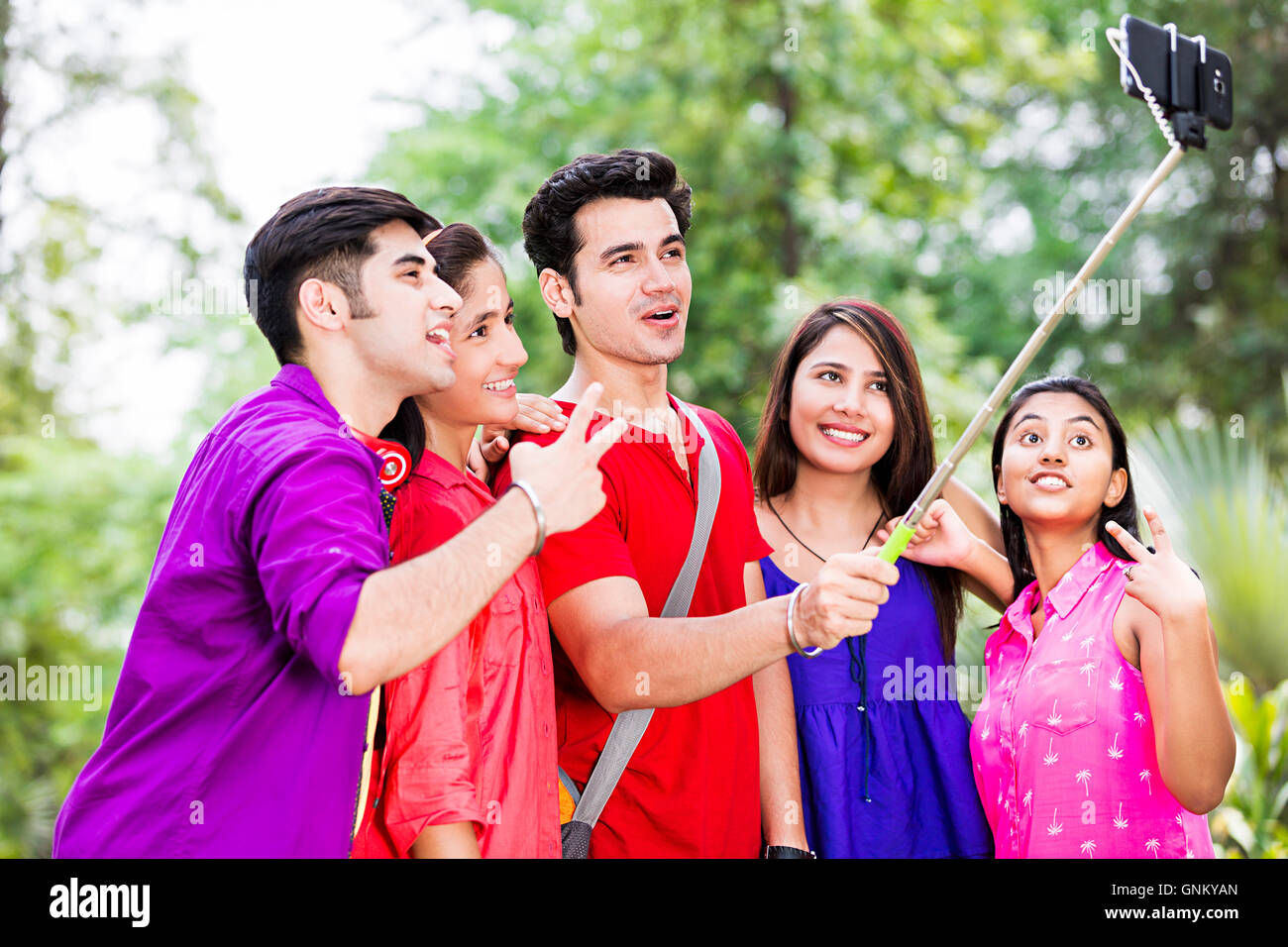 5 Young Girls And Boys Friends College Student Park Holding Selfie Stick Mobile Phone Clicking Selfie Stock Photo Alamy