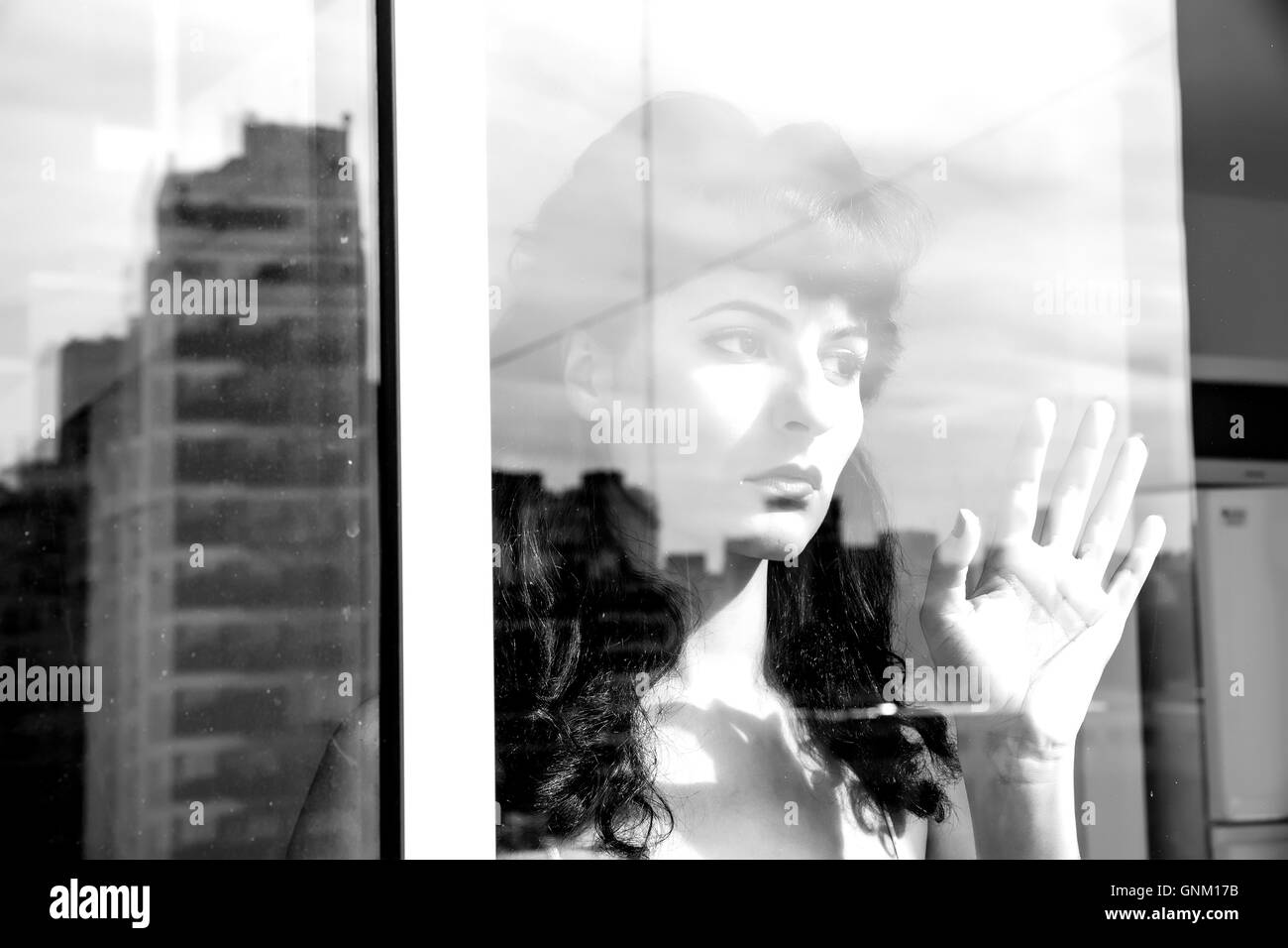 A pensive vintage girl standing behind a window Stock Photo Alamy