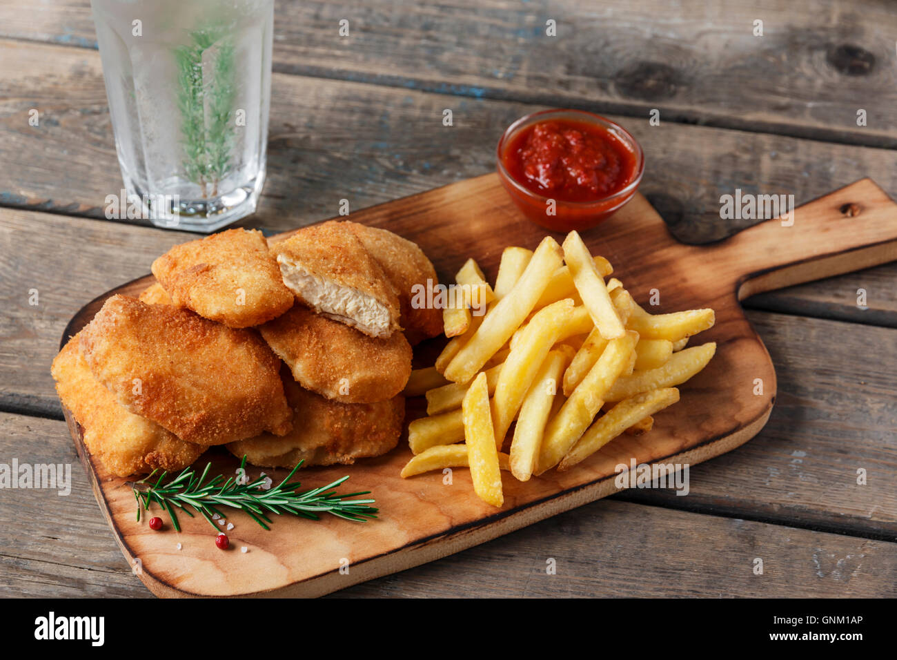 chicken nuggets french fries on the board with red sauce Stock Photo