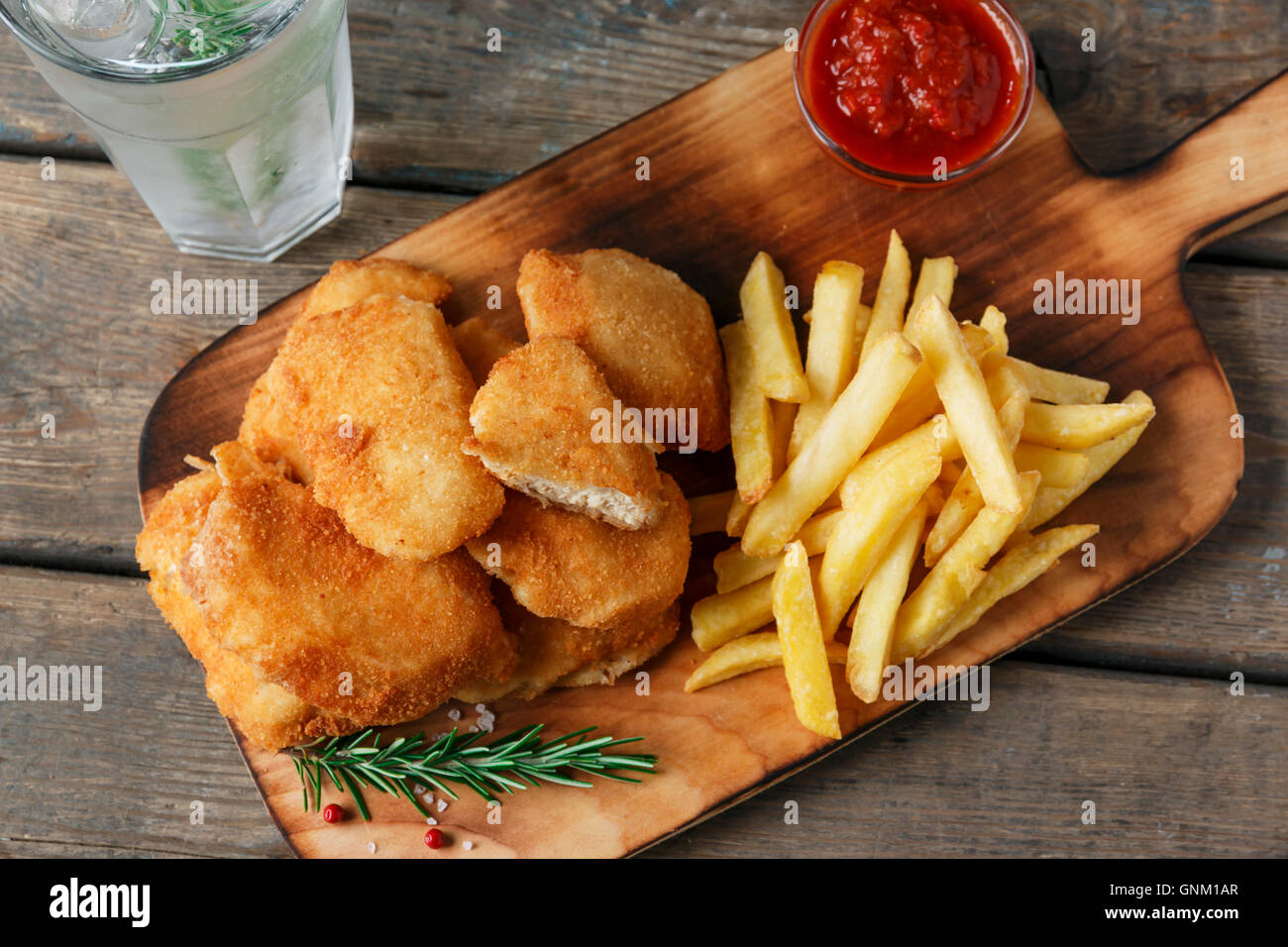 chicken nuggets french fries on the board with red sauce Stock Photo